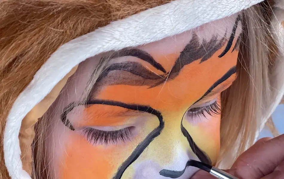 Jente som får ansiktet sitt malt til karneval