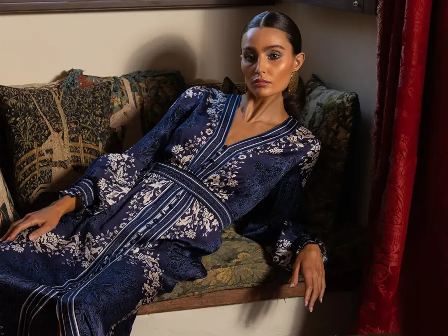 Dame sitter henslengt i en sofa