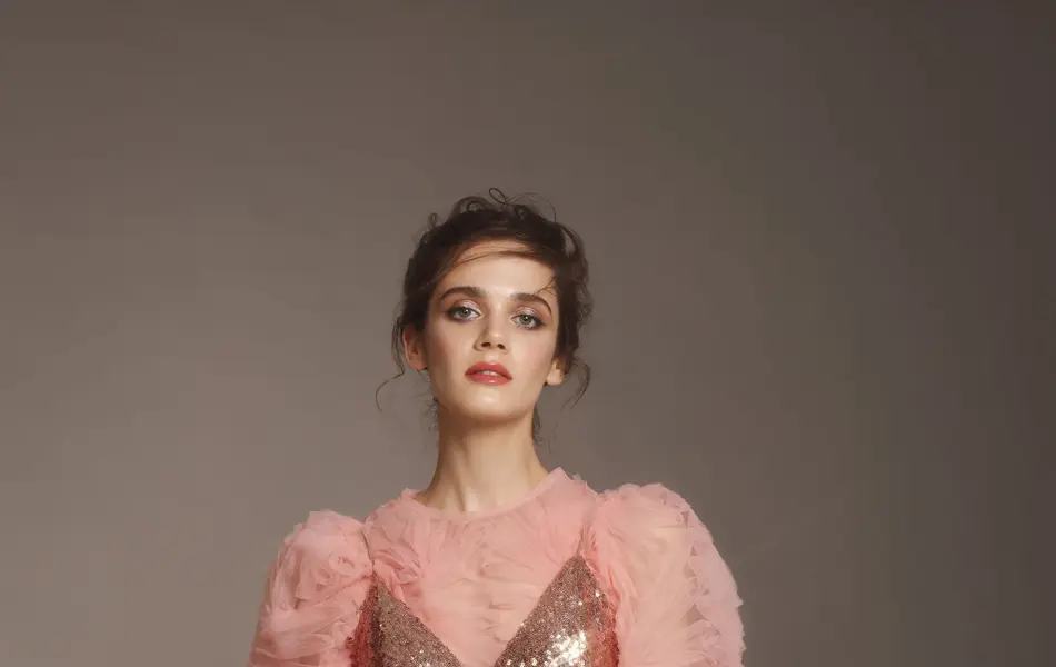 Fashionable woman in pink sequin dress and ruffle top