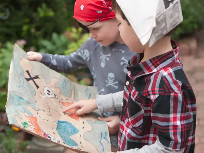 To barn kledd ut som sjørøvere holder et skattekart