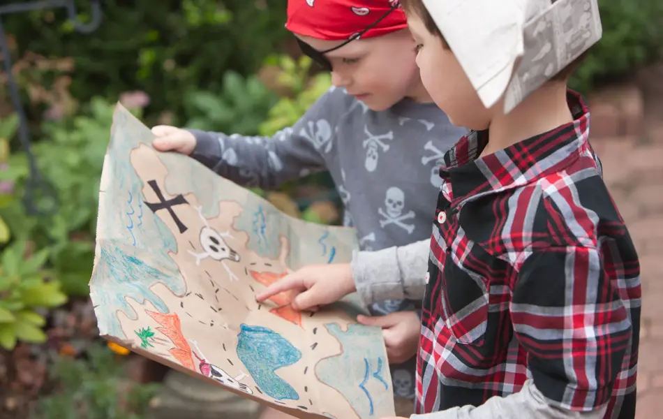 To barn kledd ut som sjørøvere holder et skattekart