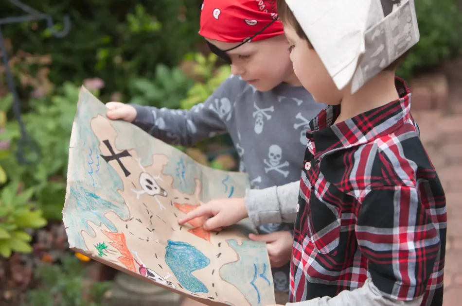 To barn kledd ut som sjørøvere holder et skattekart