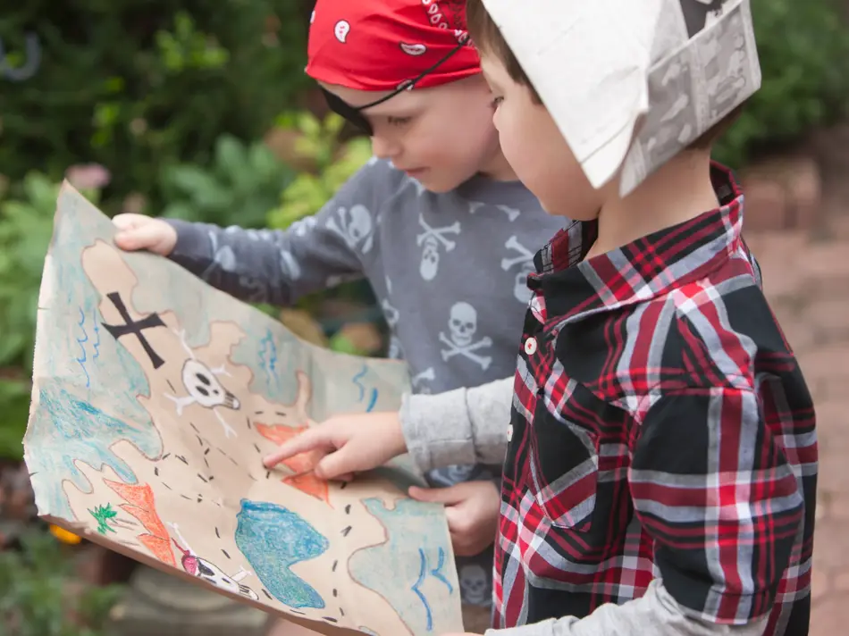 To barn kledd ut som sjørøvere holder et skattekart