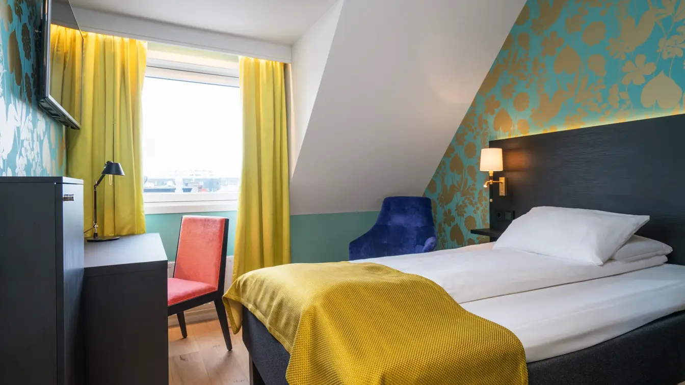 Seng og skrivebord i enkeltrom på Thon Hotel Nidaros i Trondheim
