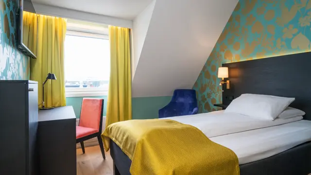 Seng og skrivebord i enkeltrom på Thon Hotel Nidaros i Trondheim