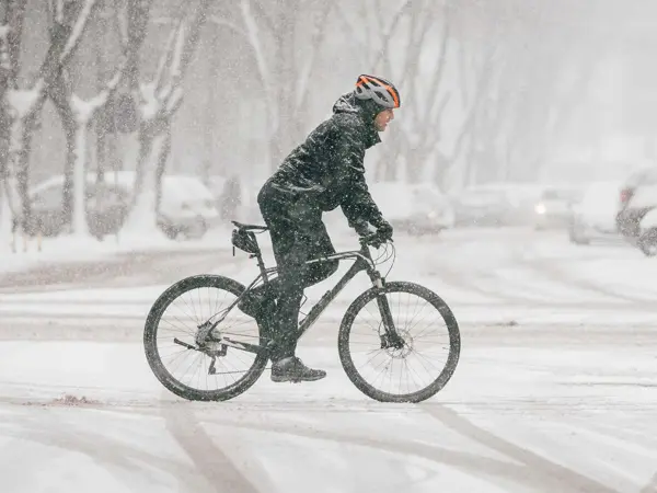Person på sykkel i urbant snølandskap