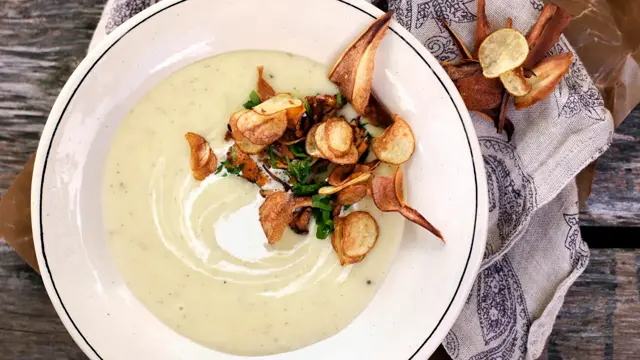 Nærbilde av potetsuppe pyntet med kantarell