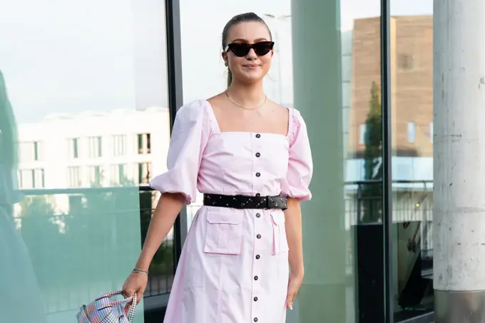 Ung kvinne i rosa kjole smiler til kamera