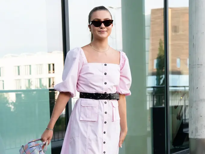 Ung kvinne i rosa kjole smiler til kamera