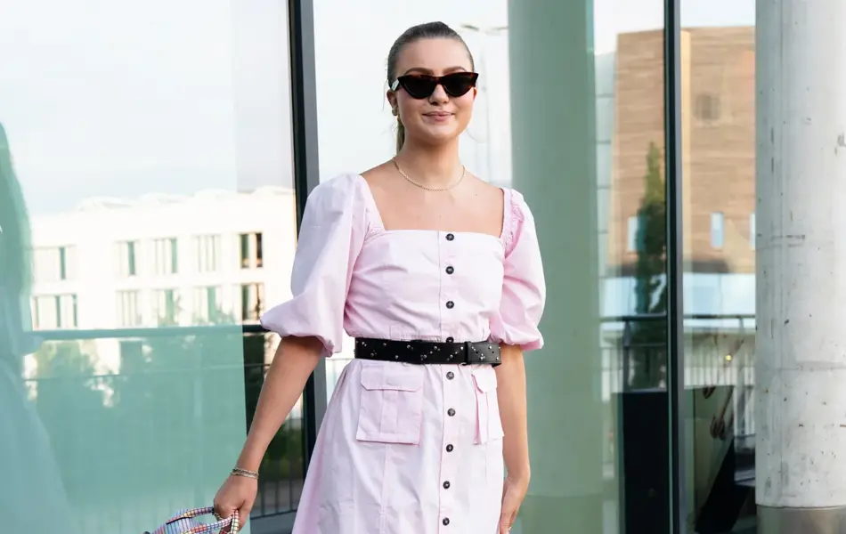 Ung kvinne i rosa kjole smiler til kamera