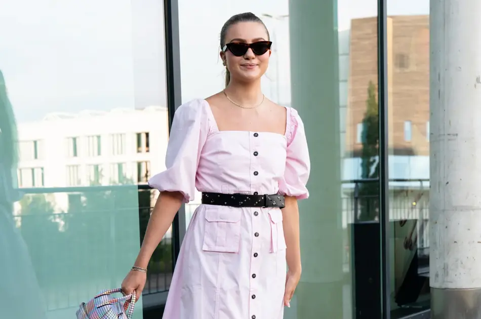 Ung kvinne i rosa kjole smiler til kamera