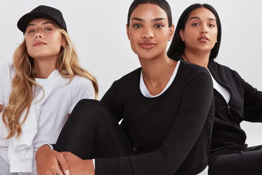 tre damer som poserer i basis klær i fargene hvit, grå og sort