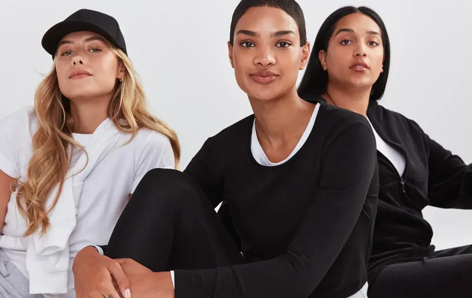 tre damer som poserer i basis klær i fargene hvit, grå og sort