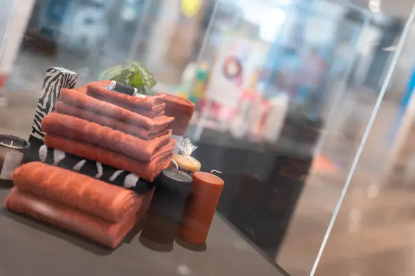 pent brettede håndklær oppsatt i utstillingsvindu, rustrøde farger