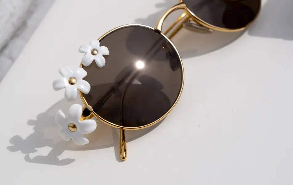 Runde solbriller med hvite blomster på siden