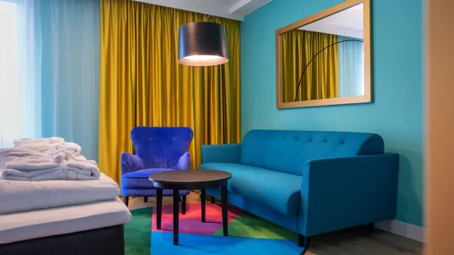 Sittegruppe med blå sofa og stol i superior HCP rom på Thon Hotel Storo