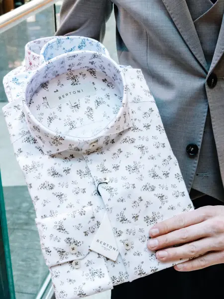 mann i dress holder skjorter