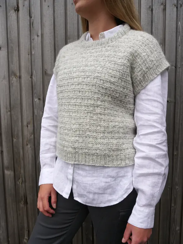 Dame med skjorte og beige strikkevest