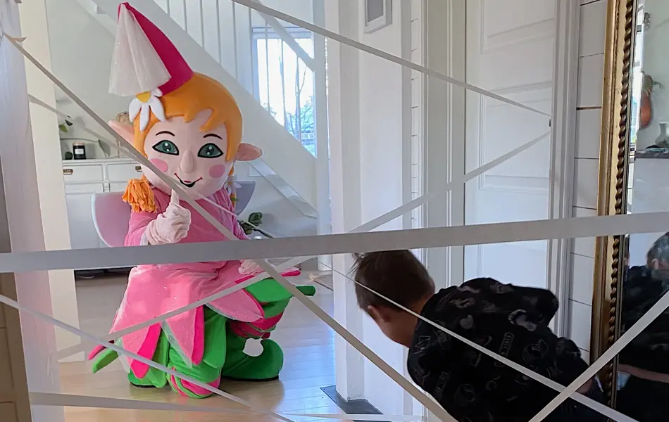 Barn som går igjennom en hinderløype laget av maskeringsteip, mens Amfelia-maskot venter ved mållinjen