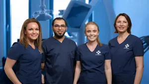 en herre og tre dame tannleger i mørkeblå uniform