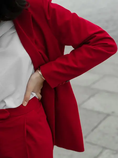 Young Caucasian woman in red pantsuit  walking in the city