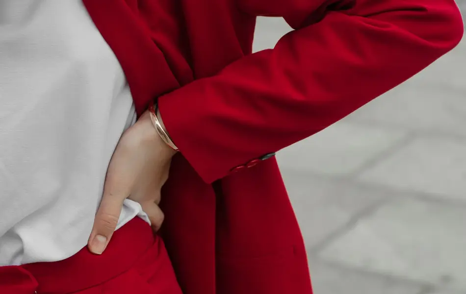 Young Caucasian woman in red pantsuit  walking in the city