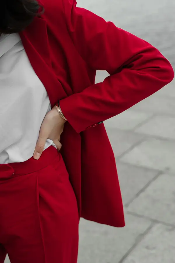 Young Caucasian woman in red pantsuit  walking in the city