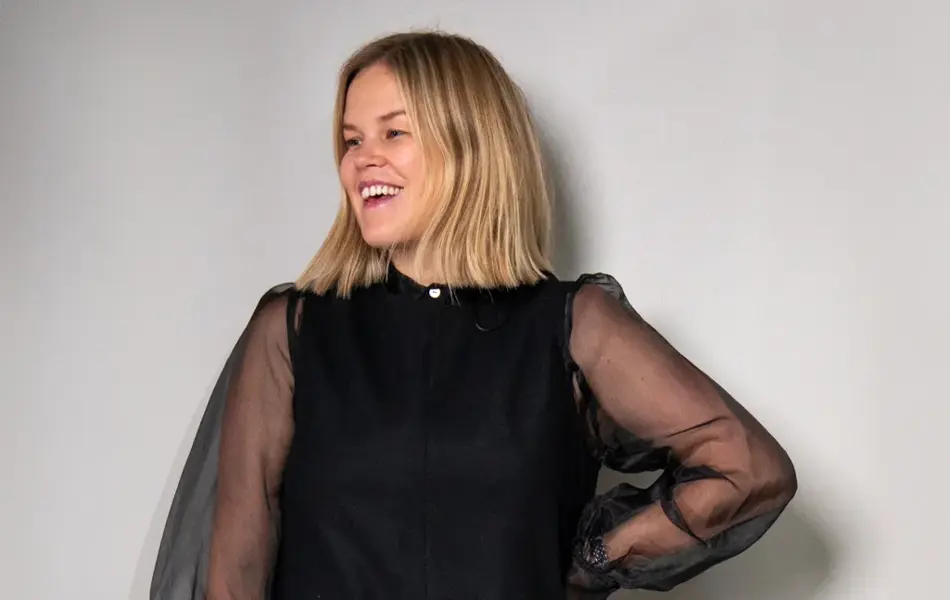 Damemodell i sort kjole med chiffonermer