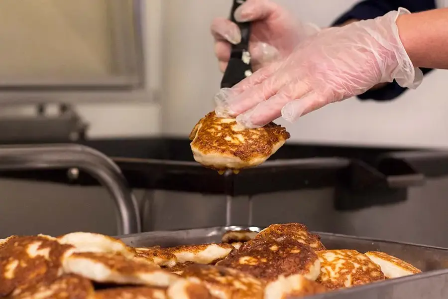 Person plukker fiskekaker fra form