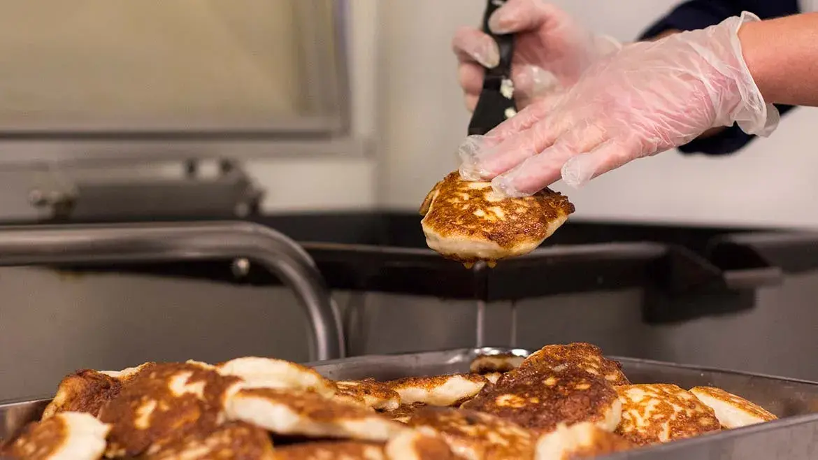 Person plukker fiskekaker fra form