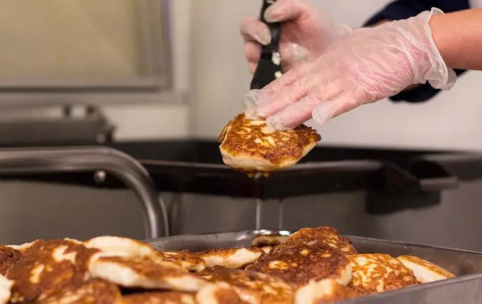 Person plukker fiskekaker fra form