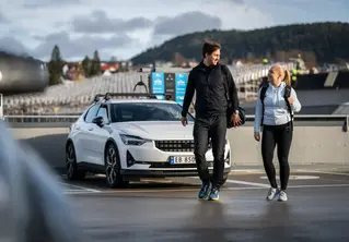 Et par som står utenfor bilen og ser på hverandre
