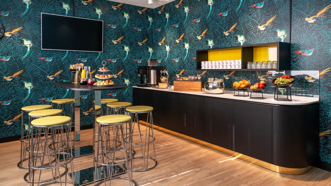 Ståbord med barkrakker og fargerik tapet med fugler i pausebuffet område på Thon Hotel Maritim