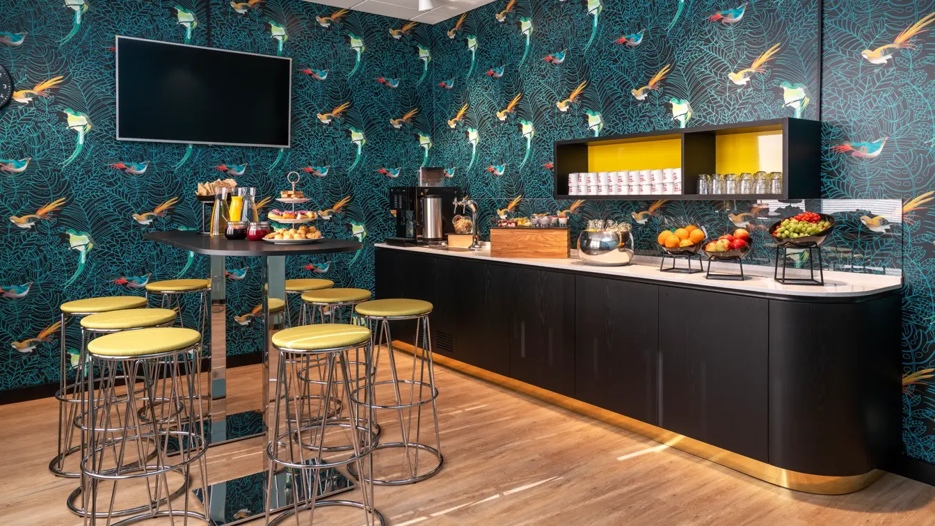 Ståbord med barkrakker og fargerik tapet med fugler i pausebuffet område på Thon Hotel Maritim