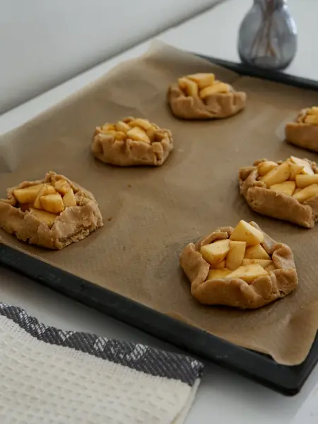 Bakebrett med seks små ustekte eplekaker