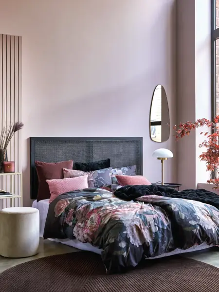 Seng med blomster sengesett og rosa vegg