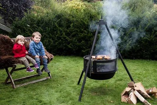 Bålpanne i en hage med to barn på en benk