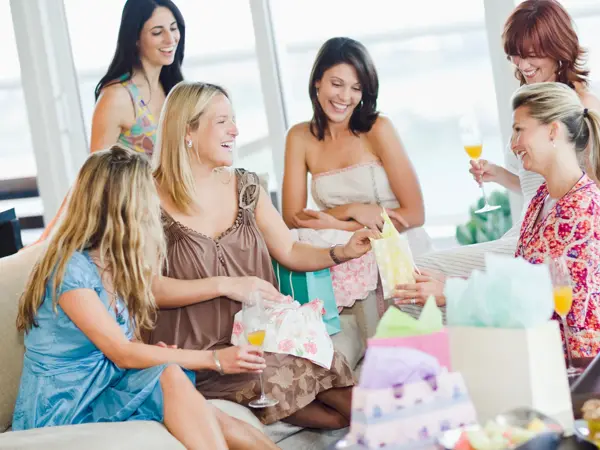 babyshower med damer som sitter rundt i stuen med gaver