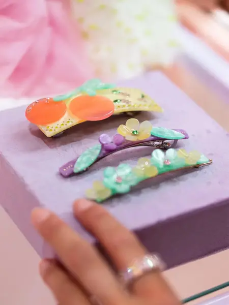 Tre dekorative hårspenner på et utstillingsbord