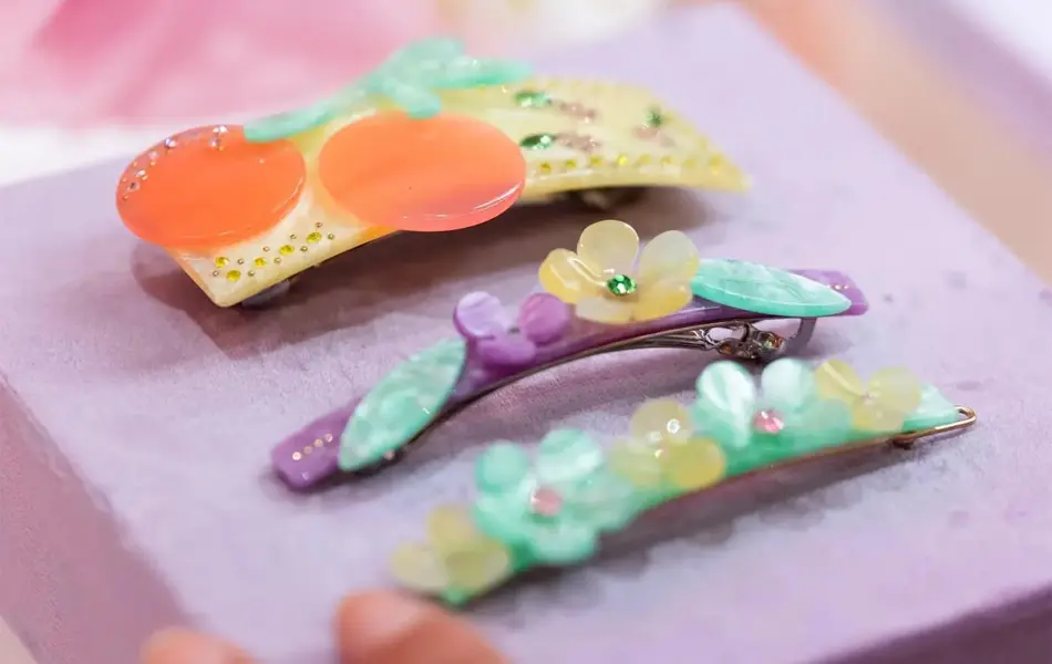 Tre dekorative hårspenner på et utstillingsbord