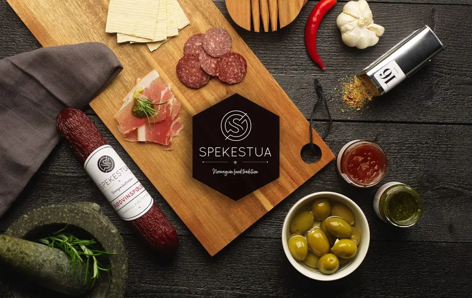 Utvalg av tapas med pølser, krydder og oliven på ei trefjøl