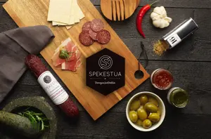 Utvalg av tapas med pølser, krydder og oliven på ei trefjøl