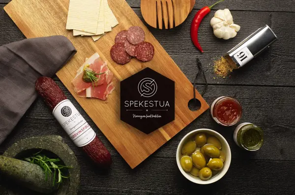 Utvalg av tapas med pølser, krydder og oliven på ei trefjøl