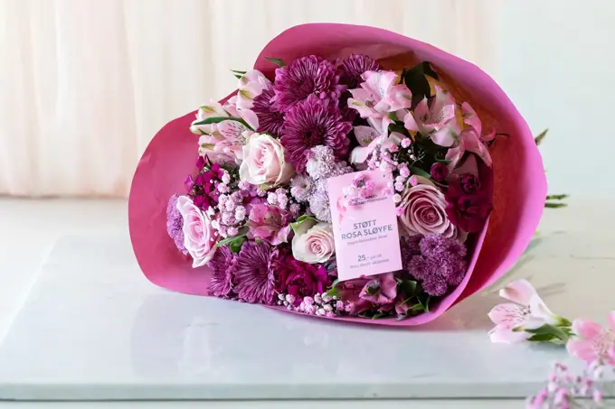 Bukett med rosa blomster på et bord, rosa sløye aksjon