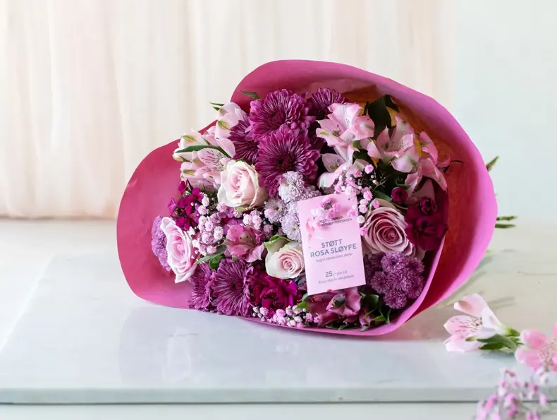 Bukett med rosa blomster på et bord, rosa sløye aksjon