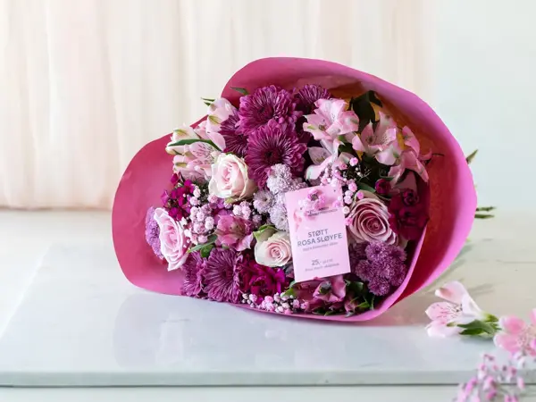 Bukett med rosa blomster på et bord, rosa sløye aksjon