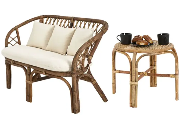 Rottingsofa med hvite puter og bord