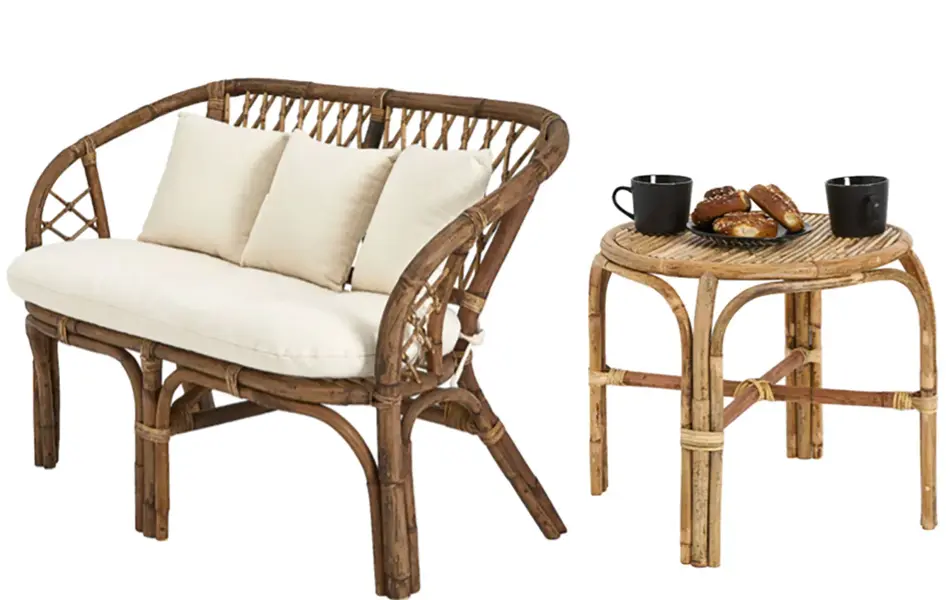 Rottingsofa med hvite puter og bord