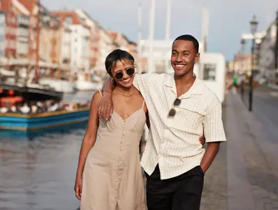 Et lykkelig par går langs gate mens de holder hender 