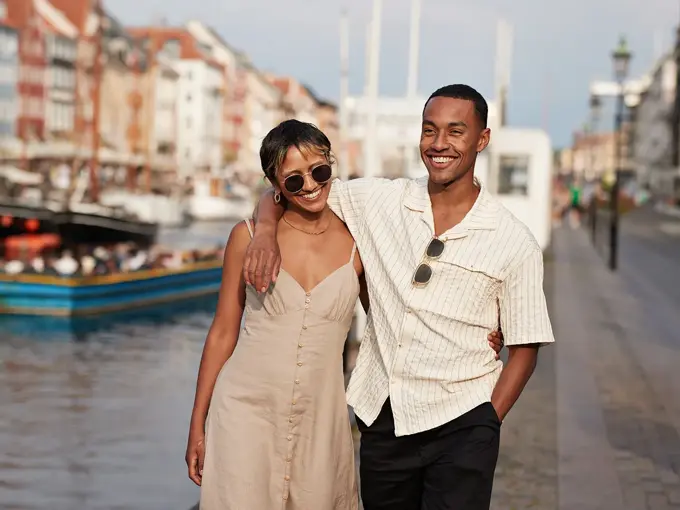 Et lykkelig par går langs gate mens de holder hender 